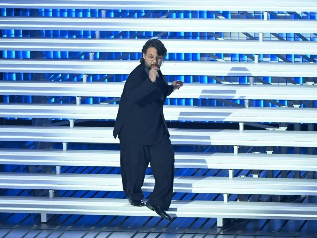 Lillo Petrolo fa il moonwalk sulle scale dell’Ariston durante Sanremo 2026: un esempio di poliedricità artistica tra comicità e performance.