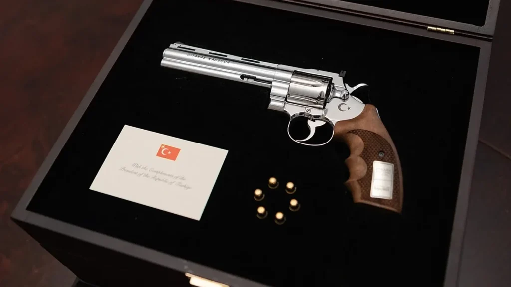 Un revolver Gümüşay .357 Magnum, regalo di Ankara dentro una custodia di legno aperta con velluto nero e sei proiettili veri, atmosfera cupa e drammatica.